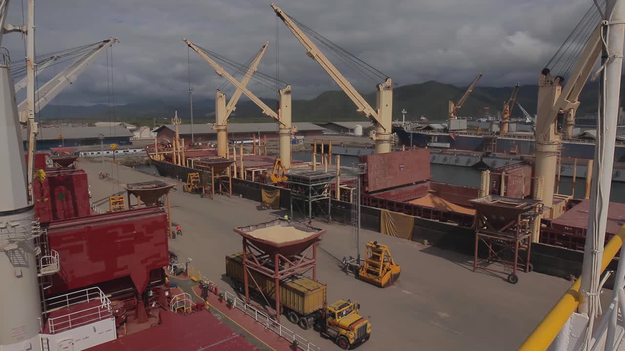 general view of a commercial port with ships berthed while unloading merchandise
