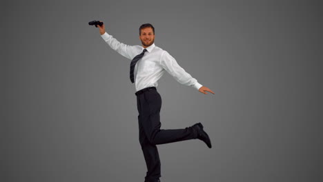 businessman jumping and holding binoculars on grey background