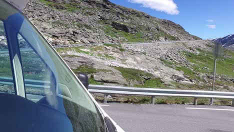 una pareja va por un camino de montaña en noruega en una autocaravana.