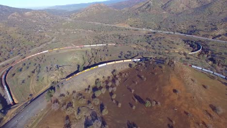 a freight train travels the remarkable tehachapi loop in california's desert making a full circle around itself