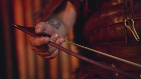 Man-plays-string-instrument-with-bow-at-concert-on-stage