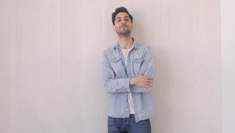 attractive man standing against a wall