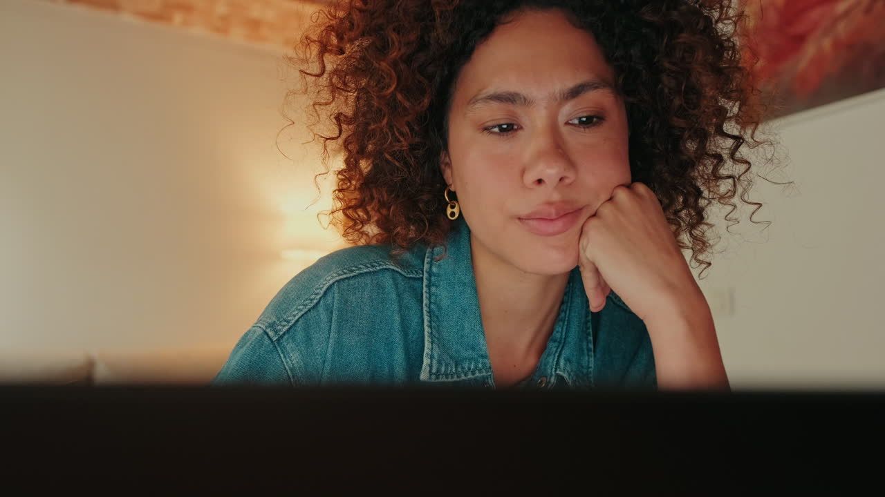 Giovane donna pensierosa concentrata sullo schermo del portatile