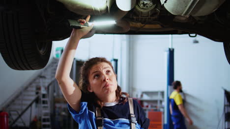 Garage-employee-working-on-suspended-car