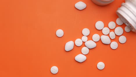 white pills on orange background