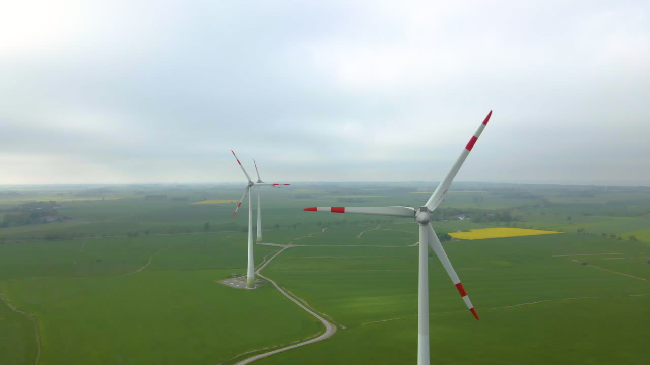 흐릿한 아침 동안 푸른 초원에 있는 아름다운 풍차 터빈