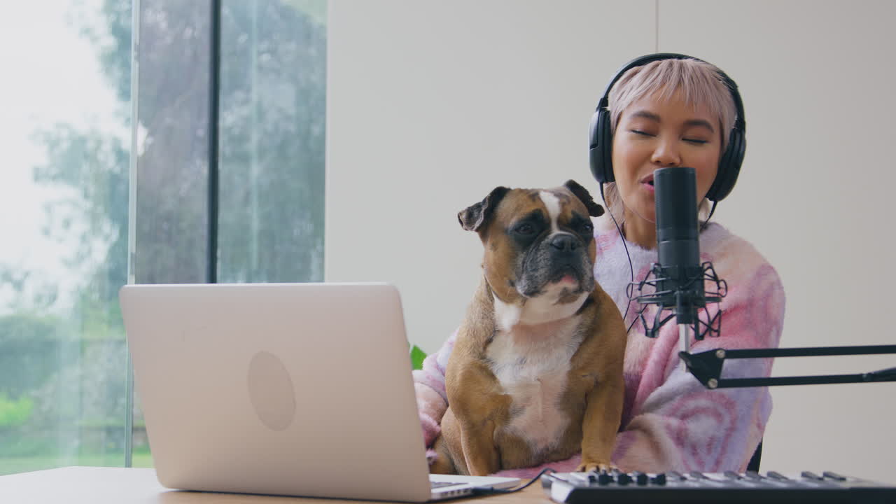 애완동물인 프랑스 불도그와 함께 캐스트를 녹음하거나 집에서 스튜디오에서 라디오를 방송하는 여성