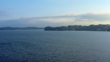 Beautiful-dolly-in-aerial-drone-shot-of-the-stunning-man-made-Guarapiranga-Reservoir-in-the-south-part-of-São-Paulo,-Brazil-with-calm-waters,-beaches,-marinas,-and-wildlife-on-a-fall-evening