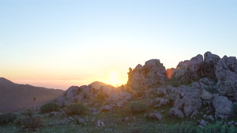 sunset over mountain peaks with hikers