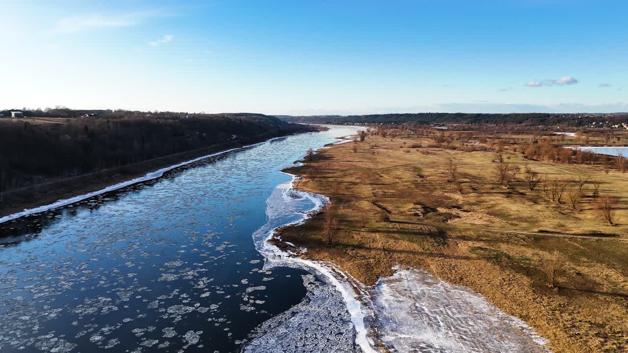 Beautiful winter river with ice pieces, aerial ascend view
