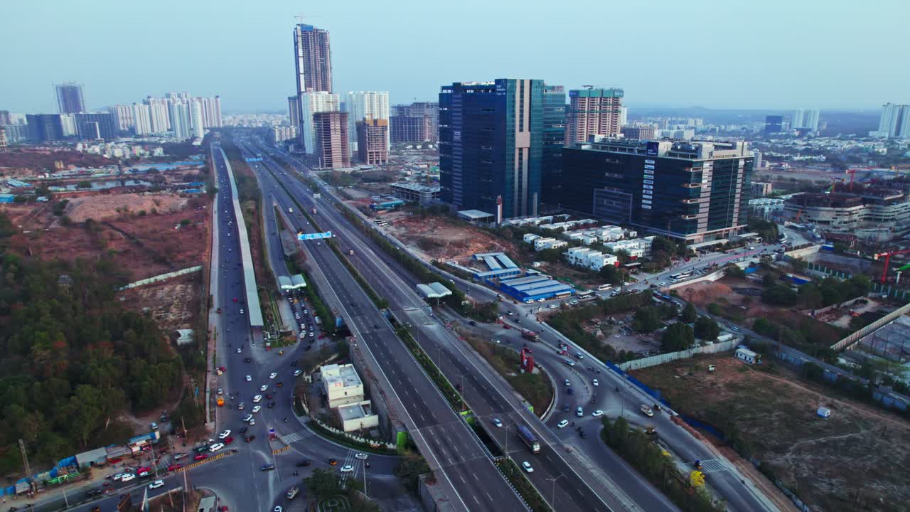 Glass facade buildings with Financial District, OOR and vehicles at Nanakramguda, Hyderabad, Telangana, india. day time, semi orbit, drone shot, 4k.
