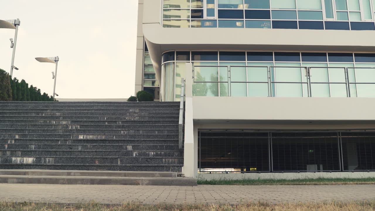 разносчик еды в терморюкзаке оставляет велосипед на земле и поднимается по лестнице, чтобы сделать доставку