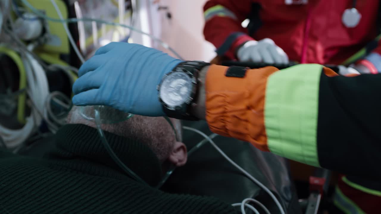 crop Paramedic Putting Oxygen Mask on Patient Crop Emergency Service Worker Putting Oxygen Mask on Face of Sick Senior Man Lying on Bench in Ambulance