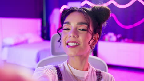 a smiling woman taking a selfie in front of neon lights