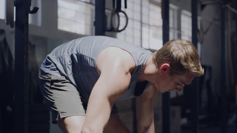 male weight lifter applying chalk to hands before