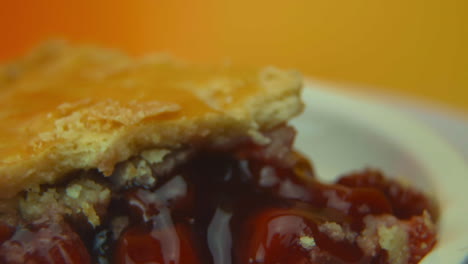 [camera used: canon c300] macro shot: a rotating cherry pie slice, with golden crust and oozing cherries