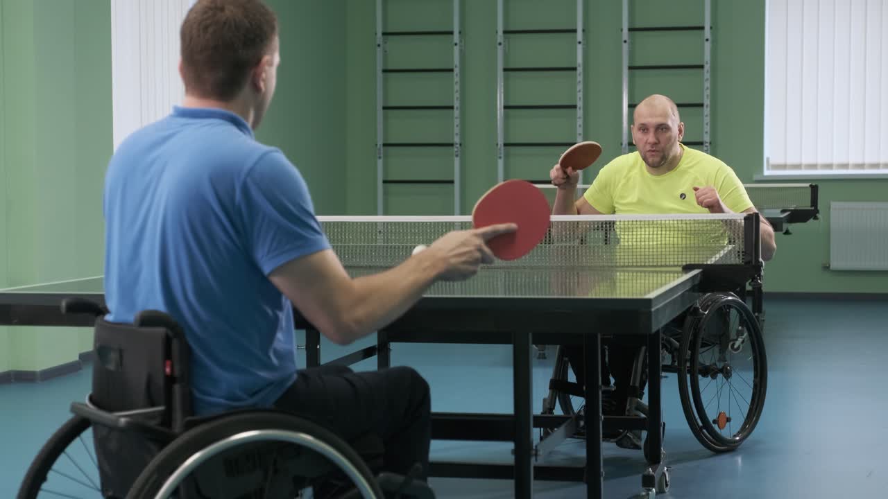 un hombre en silla de ruedas juega al ping-pong. personas con discapacidad juegan al tenis de mesa. rehabilitación de discapacitados. deporte.
