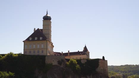 Castle-high-above-on-top-of-rock-against-blue-sky