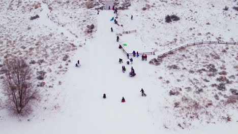 antena de un niño bajando en trineo por una colina nevada a gran velocidad