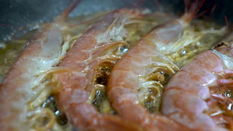 detail shot of raw prawns frying in pan