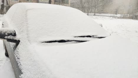 coche cubierto de nieve en el estacionamiento