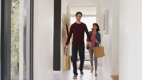 Video-of-happy-diverse-couple-returning-home-with-shopping-bags