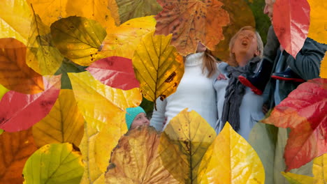 animation of autumn leaves falling over happy caucasian family in park