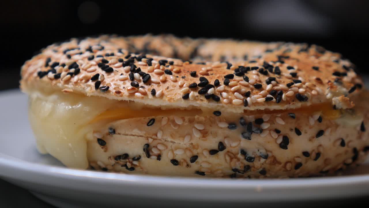 Close-up of a Bagel Sandwich with Melted Cheese and Sesame Seeds