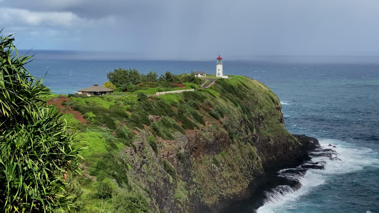 Close up of Kilauea lighthouse at Kauai's north shore with crashing waves at the cliff