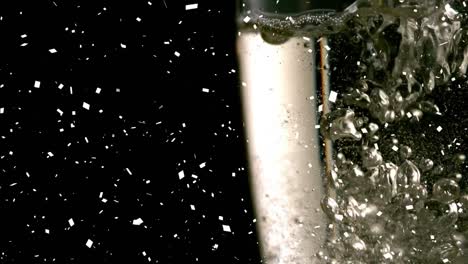Animation-of-confetti-falling-and-bubbles-rising-in-glass-of-champagne-on-black-background