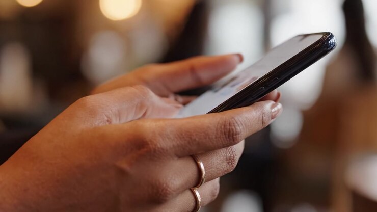 Close-Up of a Hand Interacting with a Smartphone, Highlighting the Gentle Touch and Engagement with Technology in a Modern Environment