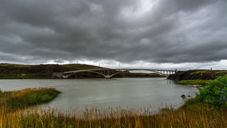 Espesas-Nubes-Grises-Sobre-El-Famoso-Puente-Hvita,-Un-Puente-De-Carretera-De-Un-Solo-Carril-Que-Atraviesa-El-Río-Hvita-En-Islandia,-Durante-Un-Día-Nublado---Lapso-De-Tiempo