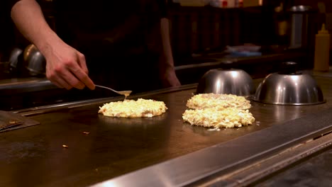 El-Chef-Japonés-De-4-K-Prepara-3-Panqueques-Japoneses-En-Un-Plato-Caliente