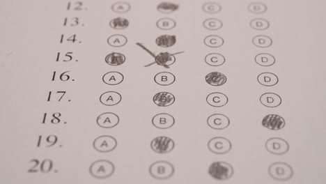 student scribbling multiple choice test bubble sheet with pencil