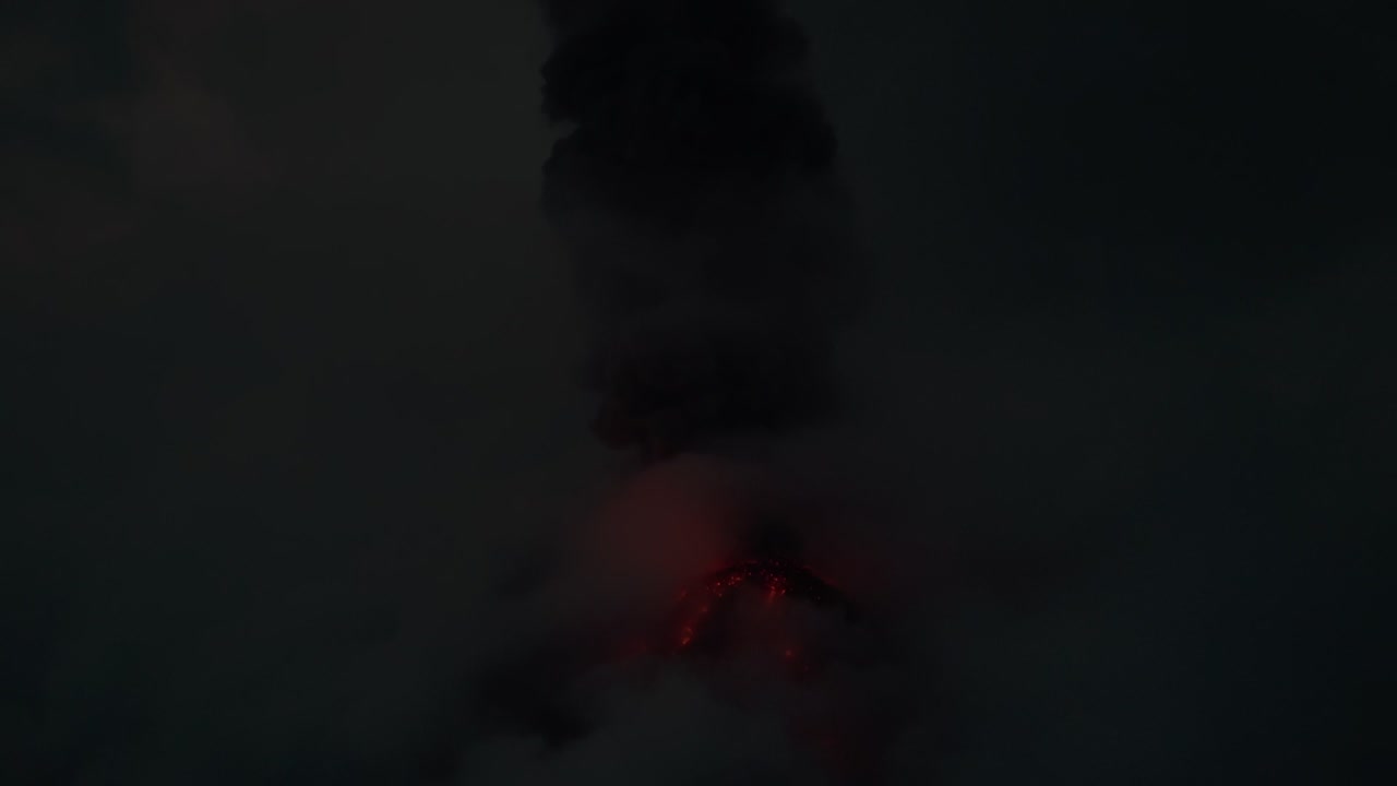 Volcan de Fuego with ash cloud and glowing lava at night in thunderstorm, aerial drone view
