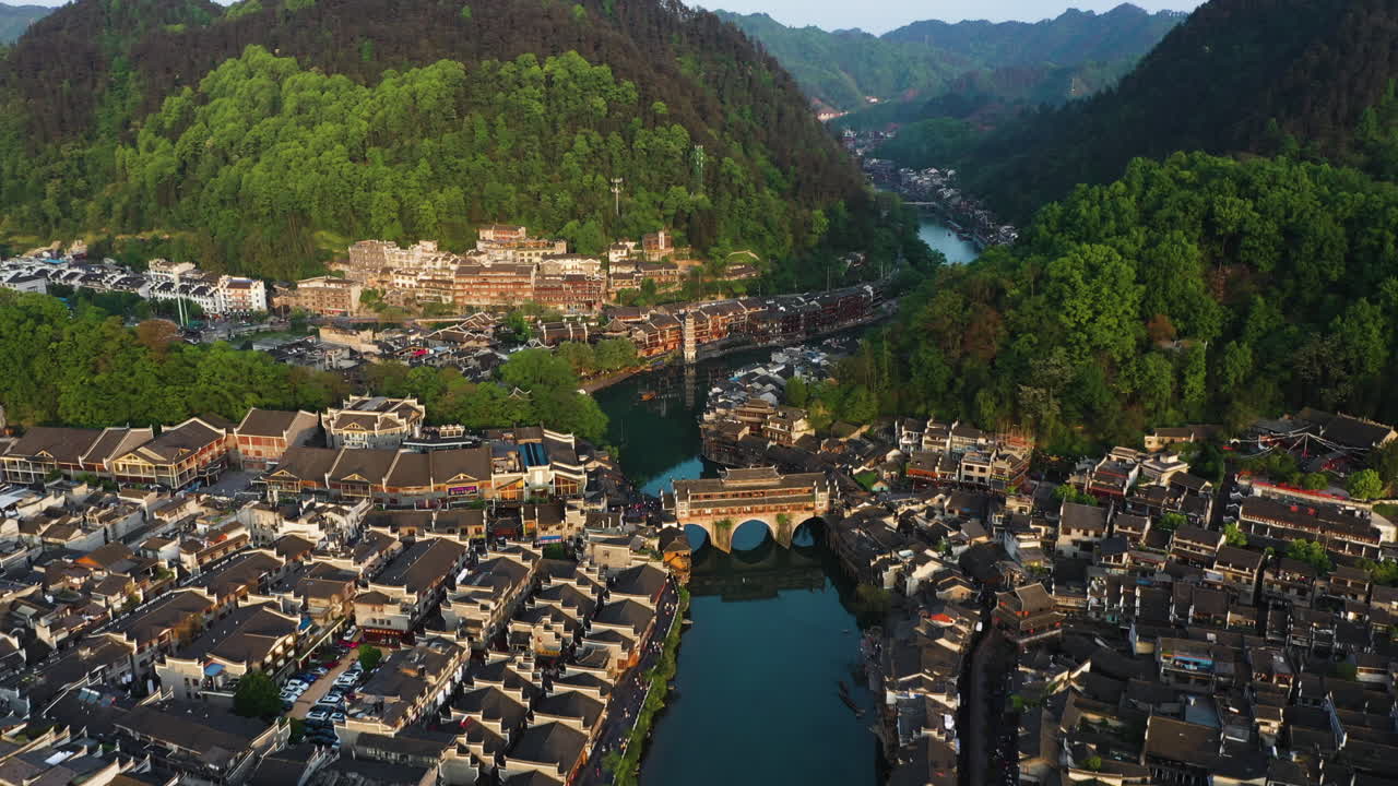 Aerial view tilting over the Phoenix Hong Bridge, golden hour in Fenghuang County, China