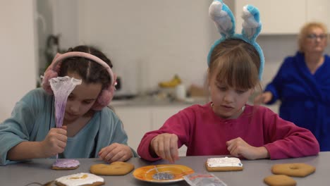 two little girls making gingerbread cookies at home.