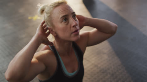 Close-up-of-fit-caucasian-woman-performing-crunches-at-the-gym