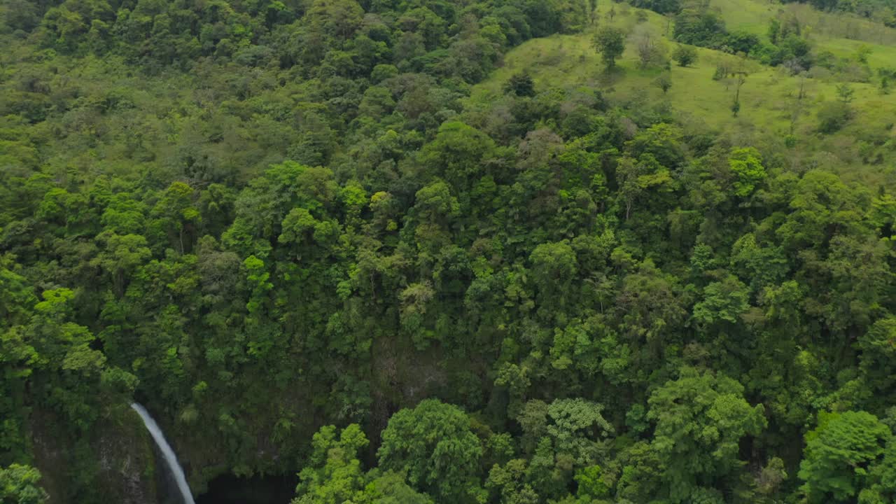 cascada de fortuna en el valle de la exuberante selva tropical y vista del volcán arenal, aérea