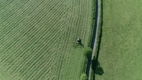 Luftaufnahme-Eines-Traktors,-Der-Das-Feld-Entlang-Einer-Ländlichen-Englischen-Landstraße-Bearbeitet