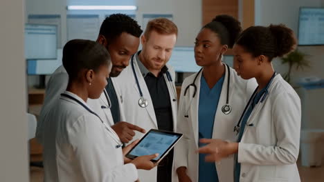 medical team discussing on tablet in hospital