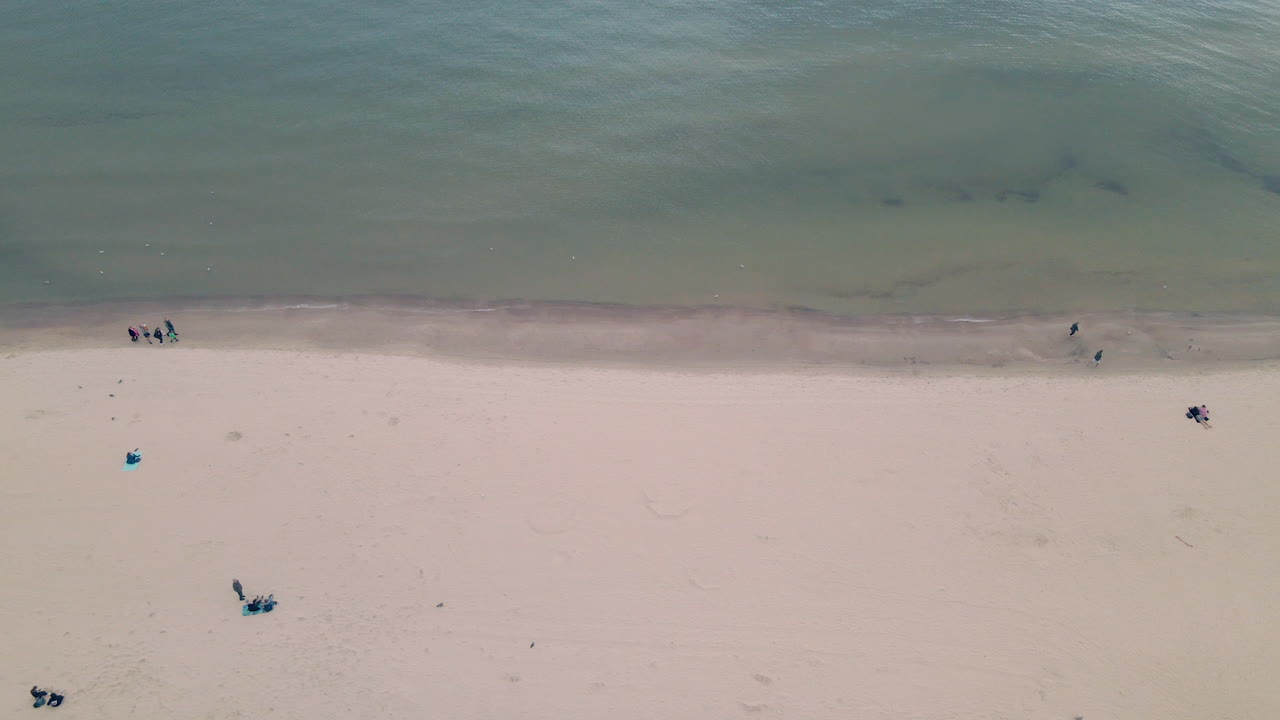 공중 하향식, 관광객들은 만의 해안을 따라 걷고, 그단스크만의 해변에 있는 소수의 사람들, 사람들은 거리를 유지합니다, 소포트