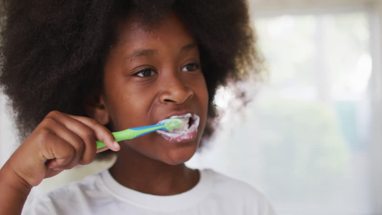 African american girl brushing her teeth in bathroom