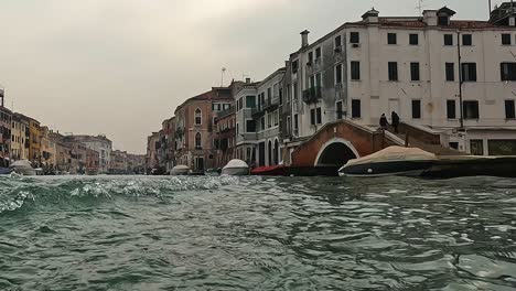 unusual low angle water surface pov of venice seen from ferry boat navigating backwards, venice in italy