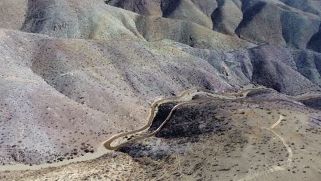 Dirt road contours remote undeveloped arid hillsides in rural Chile