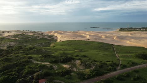 Hermosa-Toma-Con-Drone-Saliendo-Del-Medio-De-Las-Dunas-Y-Vegetación-Hacia-El-Mar,-Noreste-De-Brasil,-Mágica-Luz-Del-Atardecer