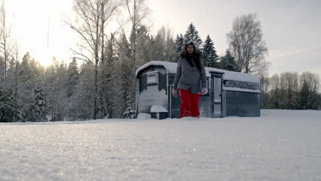 Slow-motion-woman-feet-walking-on-fresh-white-snow,-she-is-approaching-the-camera-while-kicking-the-snow,-wearing-winter-clothes-and-red-pants