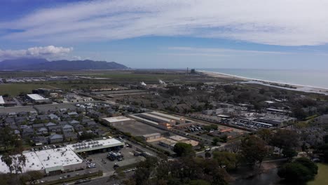 tomada aérea descendente de un parque industrial en port hueneme con el océano y las montañas de santa mónica visibles en la distancia