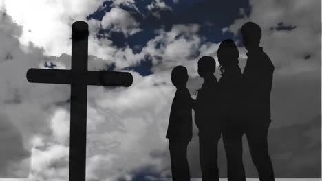 Animation-of-silhouette-of-Christian-cross-and-a-silhouette-family-of-four