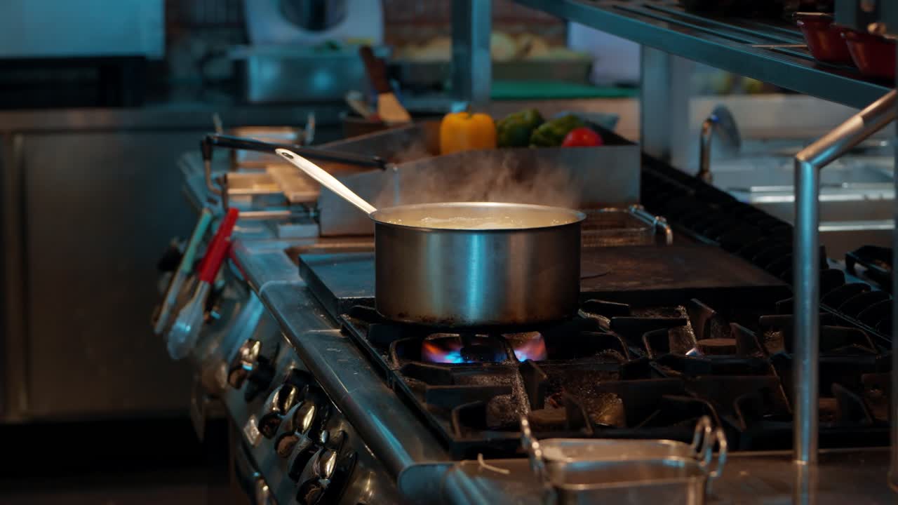 Essential process of cooking in a restaurant, showing a stainless steel pot boiling over a hot gas flame with steam rising, a fundamental step in food preparation